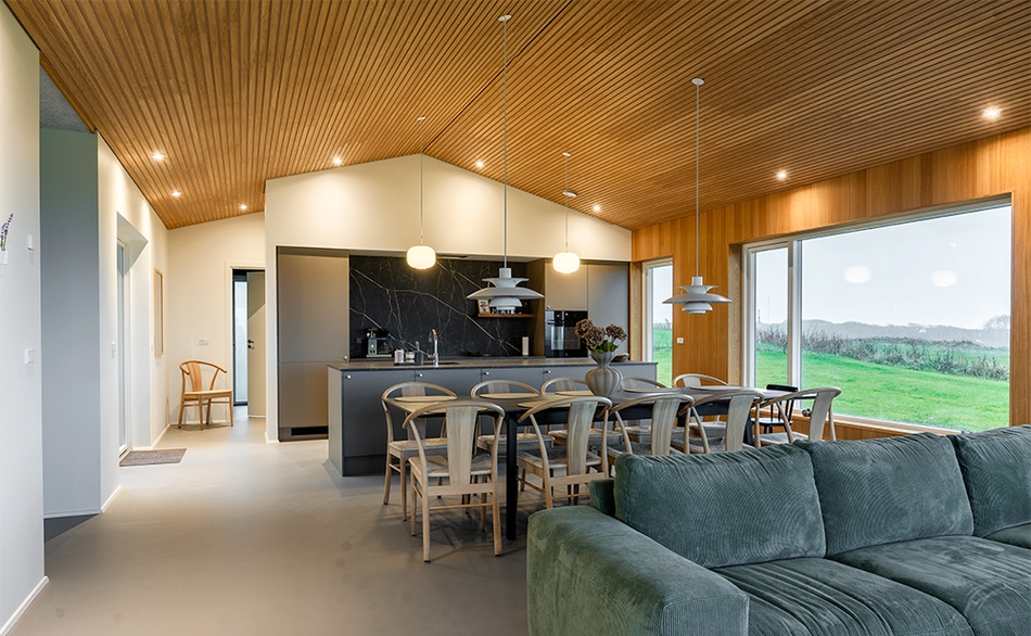 Sommerhus i Lemvig med Pro+ I-Lock® loftpaneler, UniPanel® og åbent køkken-alrum med udsigt over landskabet.