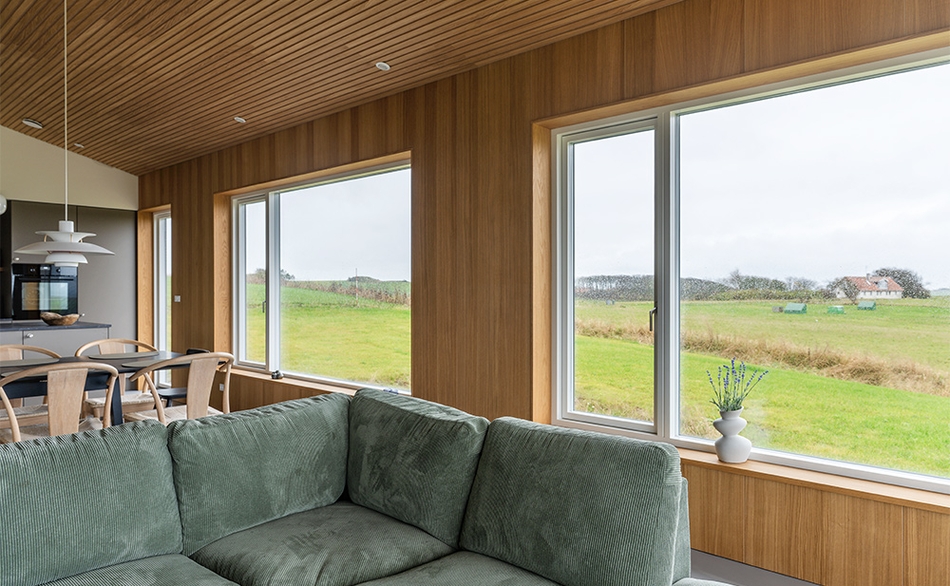 UniPanel® omkring store vinduespartier i sommerhus i Lemvig med udsigt til naturen.