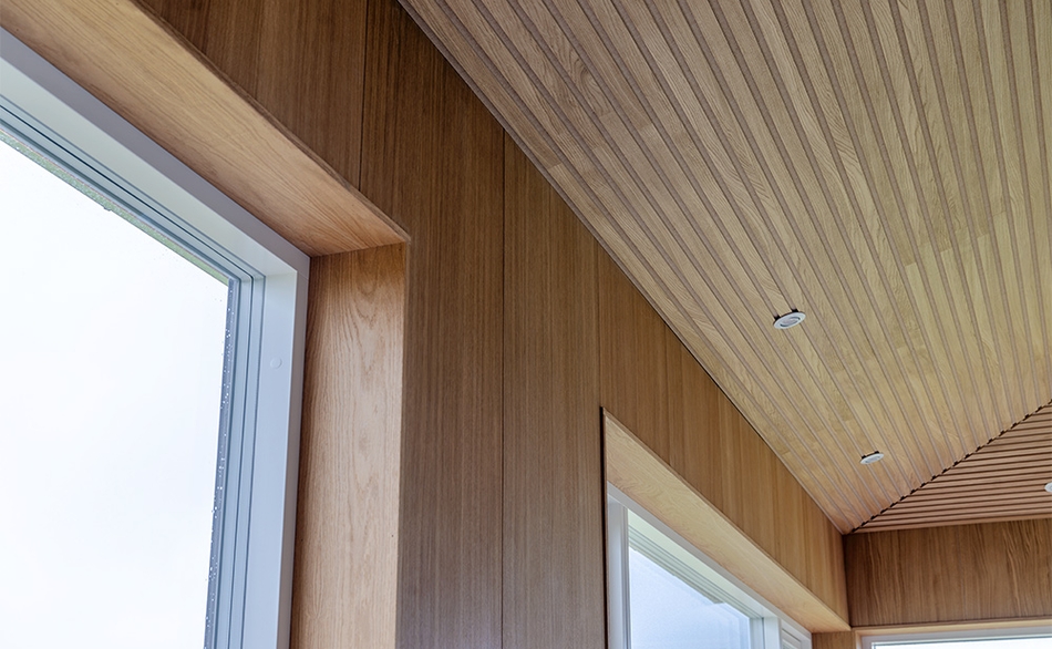 Detalje af UniPanel® og Pro+ I-Lock® loftpaneler omkring vindue i sommerhus.